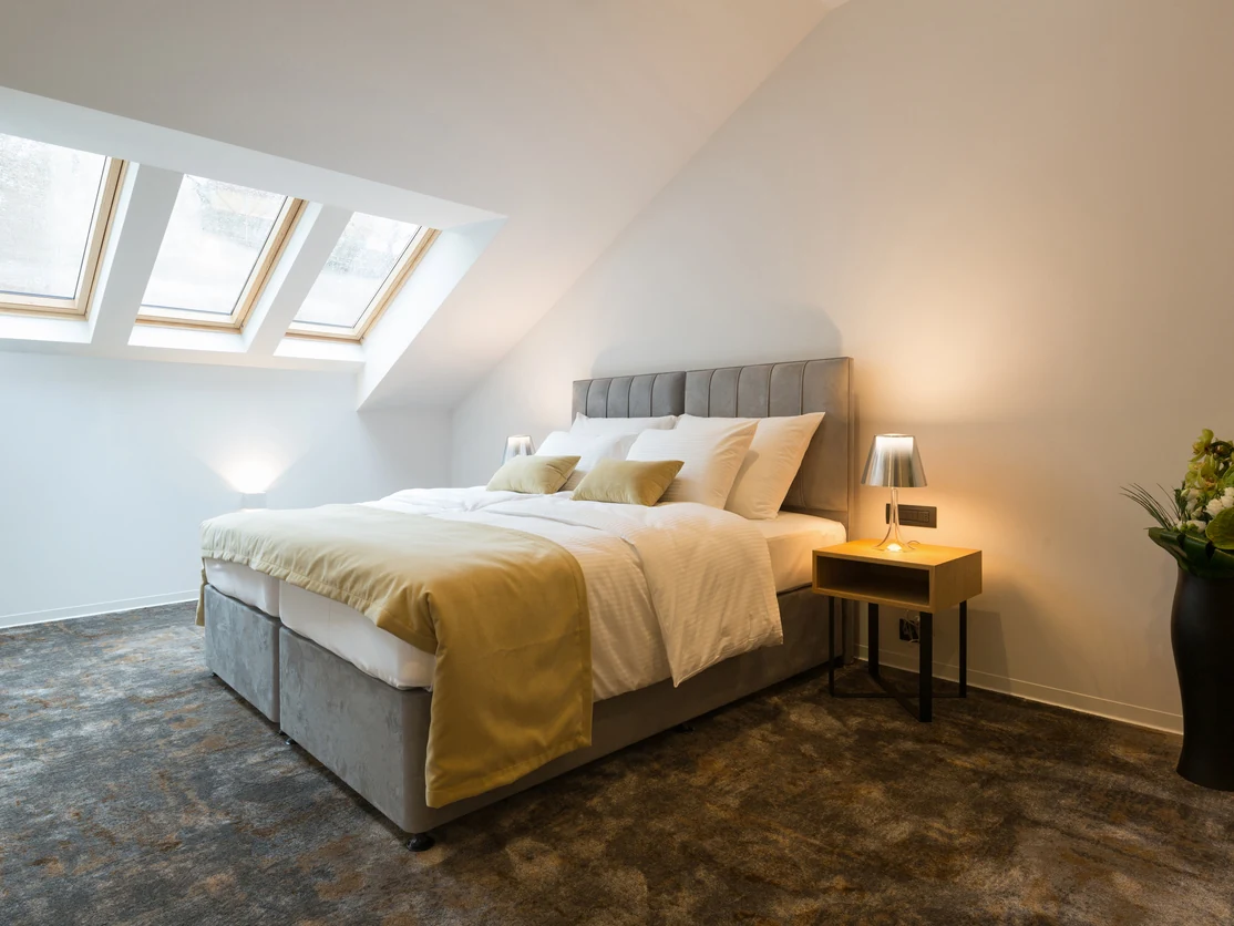 Loft bedroom with white sloped ceiling and Velux skylights, Preston bedroom-to-office conversion by Rose Decor