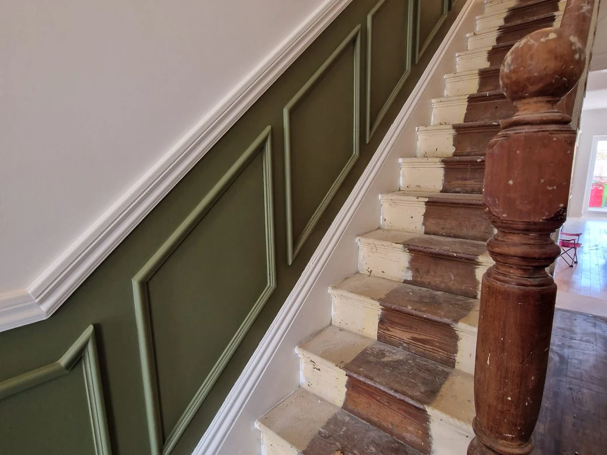 Interior staircase with sage wainscoting and white woodwork painted by Rose Decor in Preston